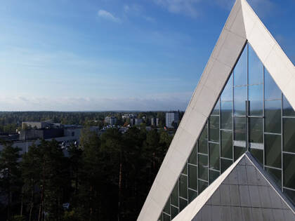 Hyvinkään kirkon kolmiokärki, taivasta ja taustalla Hyvinkään kaupunkia