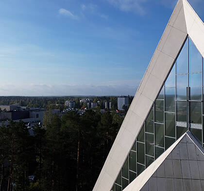 Hyvinkään kirkon kolmiokärki, taivasta ja taustalla Hyvinkään kaupunkia