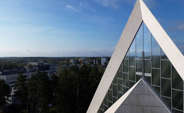 Hyvinkään kirkon kolmiokärki, taivasta ja taustalla Hyvinkään kaupunkia