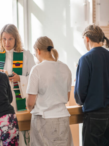 Rippikoululaisia leirikeskuksessa rukoilemassa