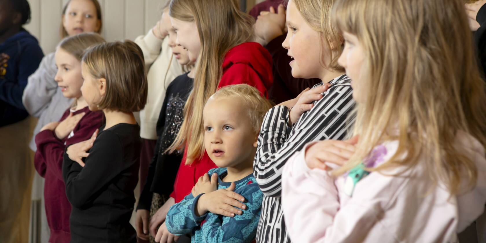 Lapsia kädet harteillaan.