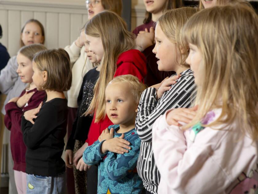 Lapsia kädet harteillaan.