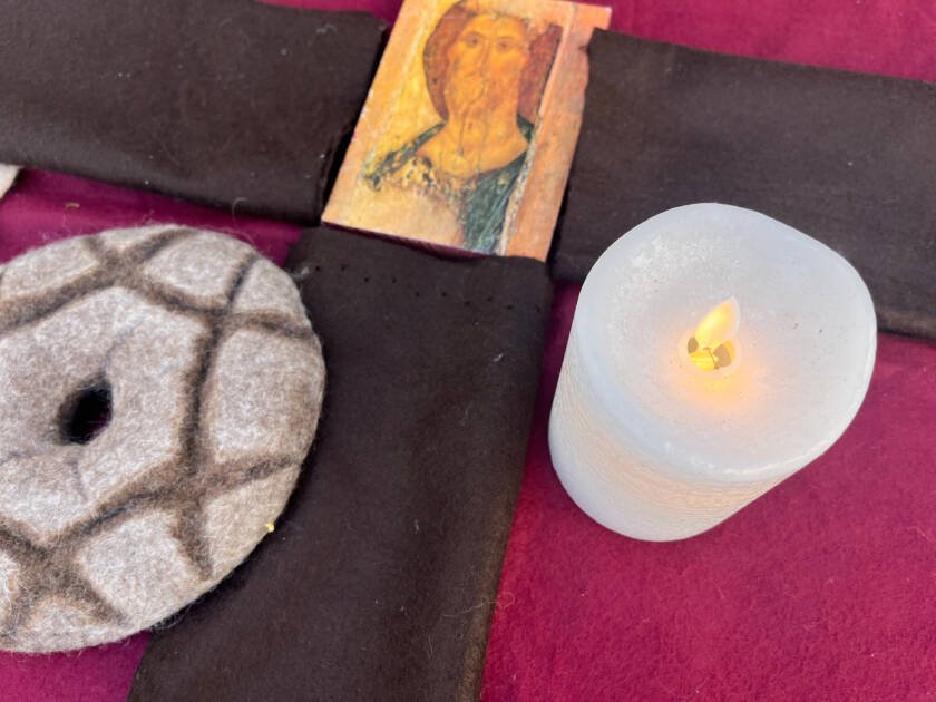 Kankaan päällä leipä, kynttilä ja Jeesus-ikoni.