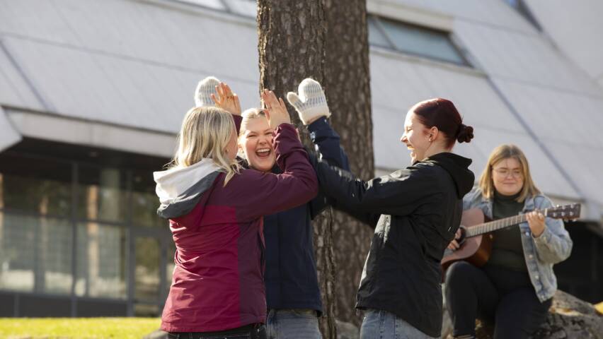 Kolme nuorta ja nuorisotyöntekijä Hyvinkään kirkon edessä.