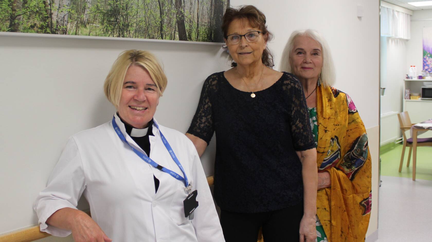 Sairaalapastori Carina Lievendahl sekä vapaaehtoiset Seija Alander-Huuhka ja Anita Myllymäki Hyvinkään sairaalan käytävällä.